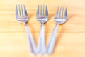 Three shniy metallic forks on a wooden table Royalty Free Stock Photo