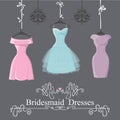 Three short bridesmaid dresses hang on ribbons