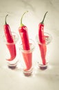 three shots of vodka and red chili pepper/three shots of vodka and red chili pepper on a white marble background. Selective focus