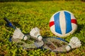 Three are on the shuttlecock rackets, badminton next to a volleyball ball