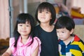 Three sibling held a photo together. Asian cute girl smiles sweetly, the boy does not look at the camera. Royalty Free Stock Photo