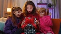 Three siblings children girls opening gift box with excited surprised face, birthday glowing present Royalty Free Stock Photo