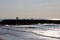 Three silhouettes of fishermen on the rock, against the light, at sunset Royalty Free Stock Photo