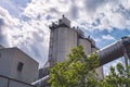 Three silos and a large pipe of a factory Royalty Free Stock Photo