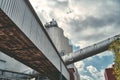 Three silos and a large pipe of a factory Royalty Free Stock Photo