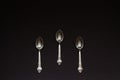 Three silver spoons on black background Royalty Free Stock Photo