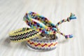 Three simple handmade homemade natural woven bracelets of friendship on white wooden table Royalty Free Stock Photo