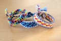 Three simple handmade homemade natural woven bracelets of friendship on wooden table Royalty Free Stock Photo