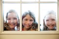 Three sister friends looking through the rainy window