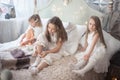 Three sisters in the bedroom dress in the morning. Girls in pajamas on the bed. Royalty Free Stock Photo