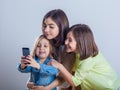 Three sisters posing and taking selfies in the studio Royalty Free Stock Photo