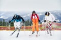 Three skiers skiing on fresh powder snow in mountains. Royalty Free Stock Photo