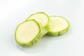 three sliced fresh green zucchini isolated, side view, placed in a white background Royalty Free Stock Photo