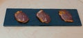 Three slices of lomo iberico on a wooden background Royalty Free Stock Photo