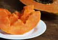 Three slices of papaya on a white plate