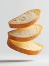 Three slices of sourdough bread float gracefully against a white background, highlighting their unique texture and color in a Royalty Free Stock Photo