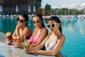 Three slim girl standing in water in swimming pool. Royalty Free Stock Photo