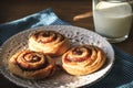 Three slug cakes on plate and cup of milk on wooden table