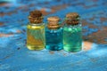 small glass bottles with colored oils stand on a worn blue table Royalty Free Stock Photo