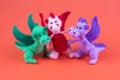 three small knitted dragons on a red background. amigurumi toys