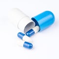 Three small pills are coming out from big blue and white capsule Royalty Free Stock Photo