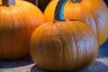 Three small pumkins together on a counter