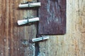 Three small rolls of white papers notification inserted into old rusty padlock hasp on the old wooden door. Bulletin sticking out