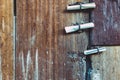 Three small rolls of white papers notification inserted into old rusty padlock hasp on the old wooden door. Bulletin sticking out