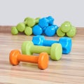 Three small rubberized dumbbells of different weights lie on the floor Royalty Free Stock Photo
