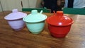 Three Small Spice Jars in Orange, Turquoise, and Purple on a Dining Table