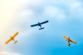 Three small two-pilot airplanes boldly making turns in the blue cloudy sky Royalty Free Stock Photo