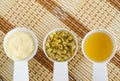 Three small white bowls with dry immortelle flowers, homemade dwarf everlast flowers infusion and herbal facial mask cream