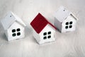 Three small wooden houses on a wooden background Royalty Free Stock Photo