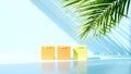 Three small yellow bars of soap arranged on a reflective surface with palm leaf shadows Royalty Free Stock Photo