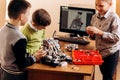 Three smart boys are making robots from the robotic constructor in the School of Robotics