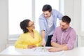 Three smiling architects working in office