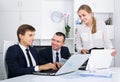 Three smiling coworkers different sexes working on computers together Royalty Free Stock Photo