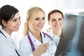 Three smiling female doctors looking at x-ray image Royalty Free Stock Photo