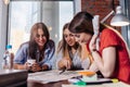 Three smiling female students learning together in classroom Royalty Free Stock Photo