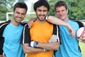 Three smiling footballers