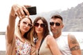 Three smiling friends taking selfie photos at digital camera of smartphone. Summer time Royalty Free Stock Photo