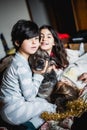 Three smiling girls in pajamas sitting on the bed hugging their big dog Royalty Free Stock Photo