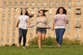 Three smiling girls run at grass Royalty Free Stock Photo