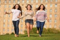 Three smiling girls run at grass and hold hands Royalty Free Stock Photo