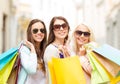 Three smiling girls with shopping bags in city Royalty Free Stock Photo