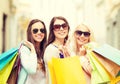 Three smiling girls with shopping bags in city Royalty Free Stock Photo