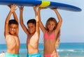 Three smiling kids boys and girl carry surfboard Royalty Free Stock Photo