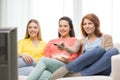 Three smiling teenage girl watching tv at home Royalty Free Stock Photo