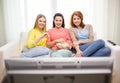Three smiling teenage girl watching tv at home Royalty Free Stock Photo