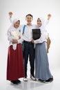 three smiling teenagers wearing school uniforms with a backpack, a book, and a laptop computer Royalty Free Stock Photo